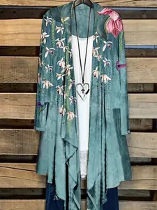 Gesamtansicht eines blauen Cardigans mit Blumenmuster über einem weißen Oberteil.
