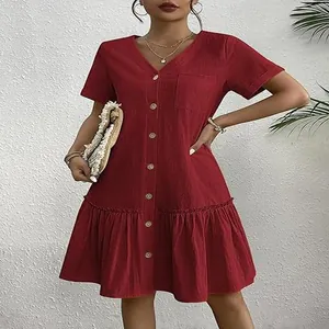 Détail de la robe rouge en coton et lin avec boutons, manches courtes et ourlet volanté