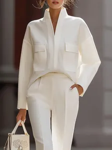 Dettaglio di un completo urbano bianco con top con colletto alla coreana e pantaloni
