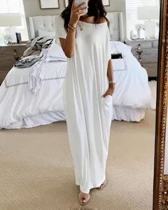 Side view of casual white short sleeve maxi dress showing pocket detail in home setting