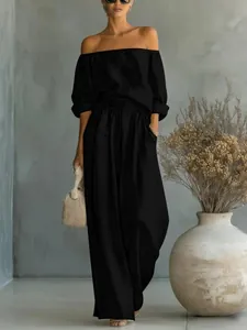 Ensemble deux pièces noir élégant pour femme avec haut à épaules dénudées et pantalon large.