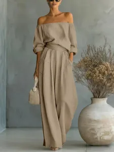 Vue complète d'un ensemble femme épaules dénudées et pantalon large en décor épuré