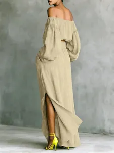 Back view of beige off-the-shoulder top and asymmetrical maxi skirt two-piece set.