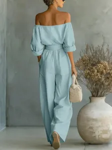 Vue arrière d'un ensemble pantalon large bleu clair à épaules dénudées avec texture lin.