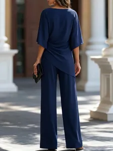 Vista posteriore di un elegante completo due pezzi blu scuro con top drappeggiato e pantaloni larghi