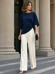 Elegante completo due pezzi con camicetta drappeggiata blu navy e pantaloni a gamba larga.