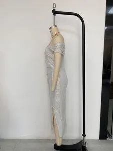 Vue latérale d'une robe de soirée à paillettes argentées avec fente latérale haute.