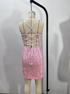 Detail view of the back of a pink sequin mini dress with an elegant cross lace-up design