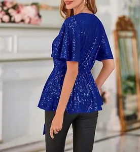 Detail view of royal blue sequined v-neck top with flare sleeves and peplum waist