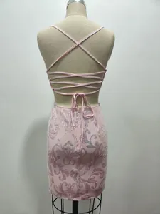 Vista detallada de la espalda de un vestido rosa de lentejuelas con tiras cruzadas.
