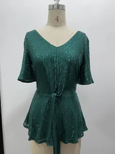 Detail view of an elegant green sequined V-neck top with bell sleeves on a mannequin.