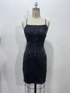 Détail d'une robe moulante à paillettes noires sur un mannequin avec de fines bretelles