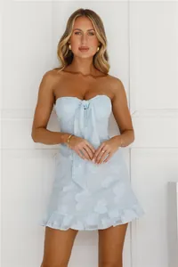 Detail of a light blue strapless mini dress with floral embroidery and bow
