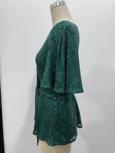 Detail of a sparkling green sequined top featuring elegant flared sleeves, side view.