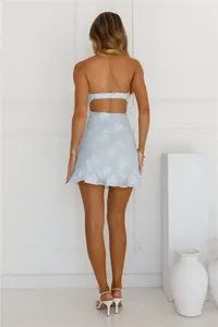 Rear view of a light blue strapless dress with floral pattern and ruffled hemline