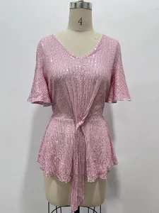 Detailed shot of a shimmering pink sequin V-neck top with elegant flare sleeves