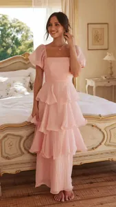 Elegante vestido largo rosa con volantes y mangas abullonadas para mujer en dormitorio