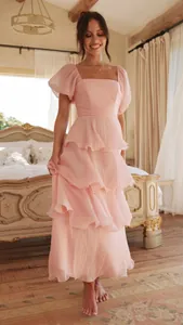 Vista completa de elegante vestido largo rosa con volantes y mangas en dormitorio vintage