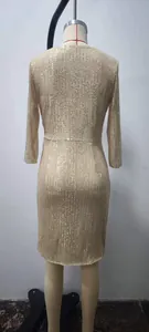 Detail view of the back of a sparkling champagne gold sequin long-sleeved dress