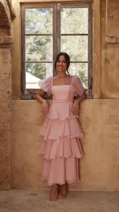 Detalle de un elegante vestido largo rosa con volantes y mangas abullonadas chic