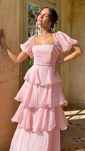 Elegante vestido largo escalonado en rosa claro con mangas abullonadas y escote cuadrado.