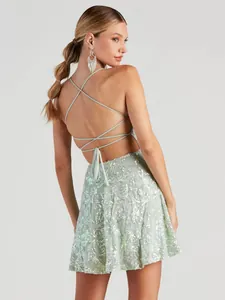 Rückansicht eines salbeigrünen Pailletten-Partykleids mit überkreuzten Schnürträgern.