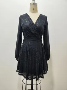 Detailed shot of black sequin mini dress featuring sheer long sleeves and V-neckline