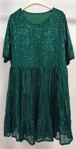 Vue détaillée du tissu à paillettes vert foncé et de l'ourlet à volants de la robe