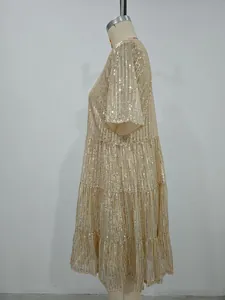 Vue latérale d'une robe de soirée à paillettes dorées avec design ample à volants