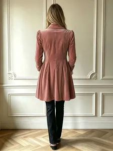 Vista posteriore di un cappotto di velluto rosa vintage con orlo a pieghe e polsini ricamati