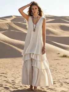 Full-length view of a bohemian sleeveless cotton linen tiered maxi dress in a desert setting.