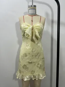 Front detail of elegant yellow strapless mini dress featuring floral jacquard and bow