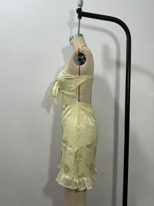 Side view of a sexy pale yellow floral strapless mini dress with bow tie details