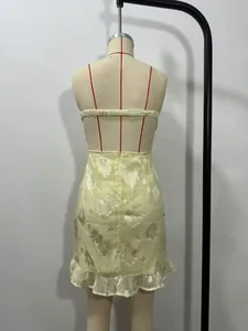 Detailed back view showing the straps of a light yellow floral jacquard mini dress.