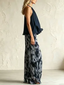 Dettaglio del set in chiffon con top halter blu navy e pantaloni larghi stampati.