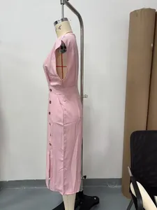Vue latérale d'une robe midi rose sans manches avec des boutons et une fente latérale.