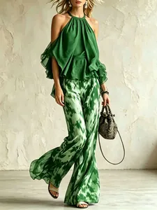 Completo estivo in chiffon con top a girocollo verde e pantaloni a gamba larga stampati.