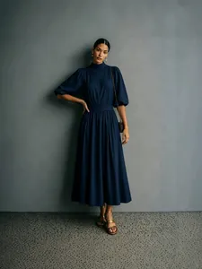 Elegante marineblauwe midi-jurk met hoge hals, pofmouwen en een getailleerde taille