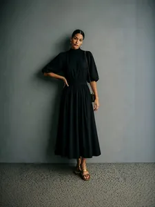 Elegante zwarte midi-jurk met pofmouwen, hoge hals en een getailleerde taille chic