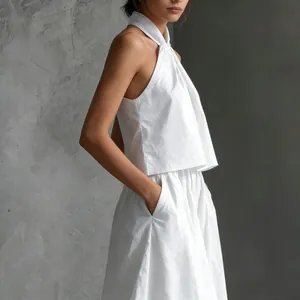 Vista lateral de un elegante conjunto blanco de top halter sin mangas y pantalón ancho