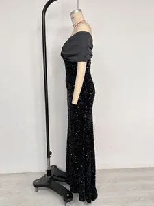 Vista lateral de un vestido de noche de sirena con lentejuelas negras y hombros caídos