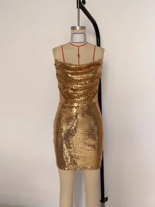 Close-up of glamorous gold sequined mini dress with cowl neck on studio mannequin.