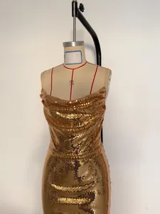 Elegant shimmering gold sequin texture and cowl neckline detail on a party dress.