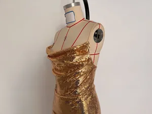 Detailed side view showing the shimmering gold sequined fabric of a party mini dress