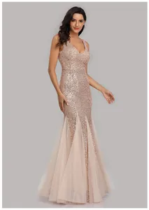 Elegant rose gold sequined mermaid evening gown with sheer tulle skirt panels.