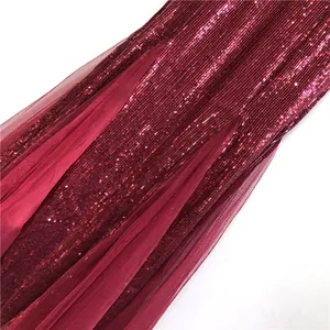 Close-up detail of burgundy sequin evening dress with elegant tulle mesh fabric.