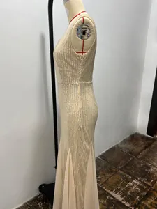 Detailed side view of a sparkling champagne sequin mermaid evening gown on a mannequin