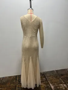 Detailed back view of a sparkling champagne sequined mermaid evening gown displayed on a mannequin