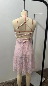 Detail eines rosa Pailletten-Partykleids mit überkreuzten Trägern am Rücken.
