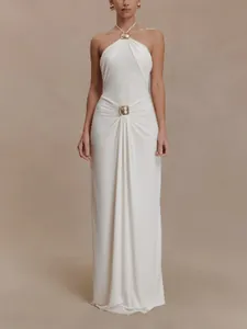 Elegant white halter neck maxi dress with gold hardware accents and waist draping detail